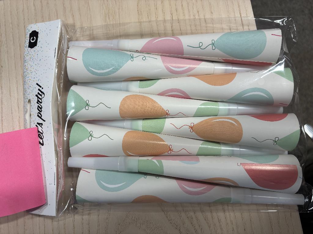 Festartikel i form av papperstuta.
Tutan används för att göra festliga ljud.
Tutan är ca 20 cm lång, tillverkad av mönstrat papper (vit botten med motiv av ballonger i olika färger) och har ett munstycke av plast (polypropen (pp)).
Festartikeln är förpackad för försäljning i detaljhandeln och föreligger om åtta tutor i en plastpåse försedd med pappryttare med utstansat hål för upphängning i butik.