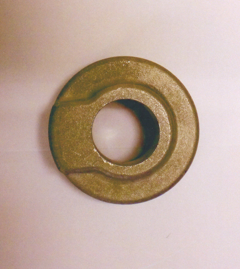 Smidd låsbricka av stål med centrerat hål och sexkantig insida. Brickan har en yttre diameter av 105 mm, en inre diameter av 55 mm och en höjd av 35 mm. Låsbrickan är en igenkännlig del till värmeväxlare.