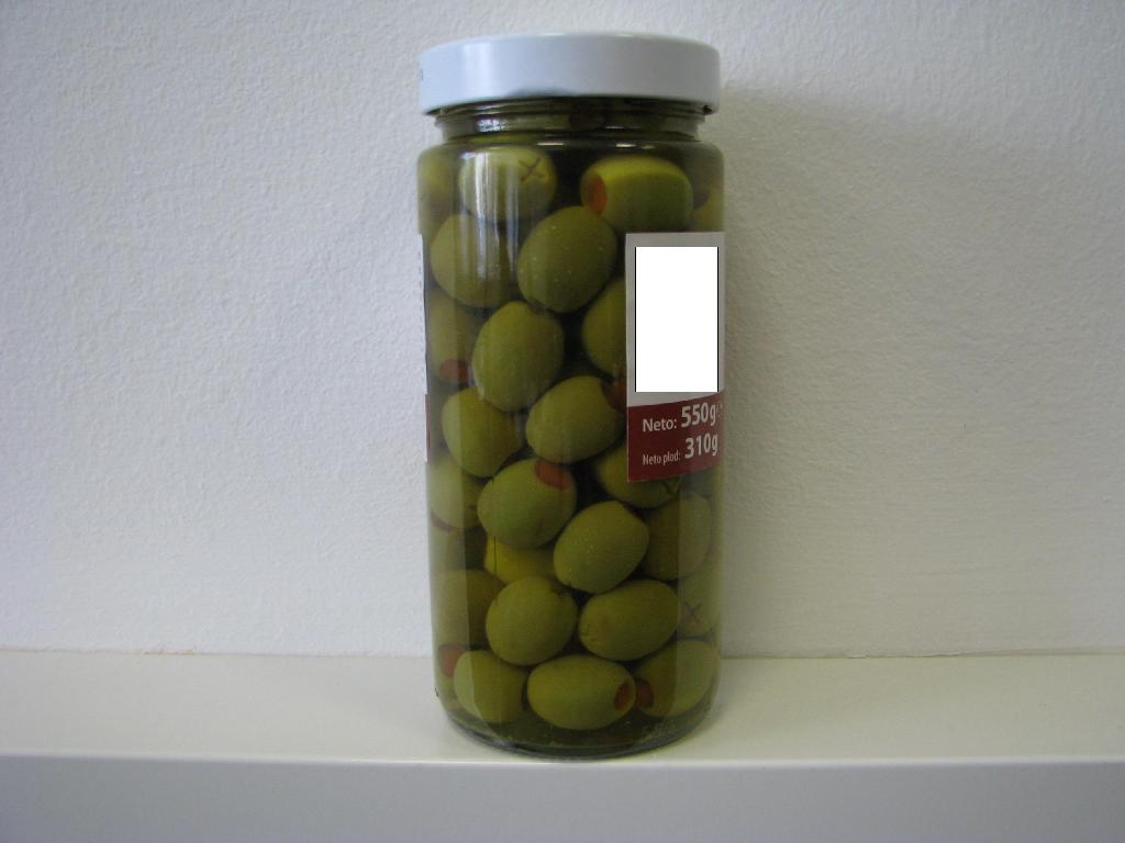 Pasterizirane zelene namizne oljke v slanici, polnjene s pasto iz paprike. Osnovne sestavine so zelene oljke, voda, pasta iz paprik (paprika, voda, Na-alginat, guar guma), sol, citronska in askorbinska kislina.  
Proizvod vsebuje manj kot 0,5 mas. % proste hlapljive kisline, izražene kot ocetna kislina in je namenjen takojšnjemu uživanju.

Pakirano v steklene kozarce po 550 g neto.