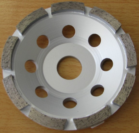 Izdelek je krožna brusilna glava premera 115 mm ima nosilni del narejen iz visoko kakovostnega jekla. Na spodnji strani so po robu prilotani brusilni segmenti, debeline 5 mm in širine 8 mm iz sintranega sintetičnega diamanta. Posamezni segmenti so (merjeno na sredini) dolgi 30 mm. V poševnem pasu glave je izvrtanih osem lukenj premera 12 mm. Na sredini je luknja s premerom 22 mm. Izdelek je namenjen za strojno brušenje betonskih površin.