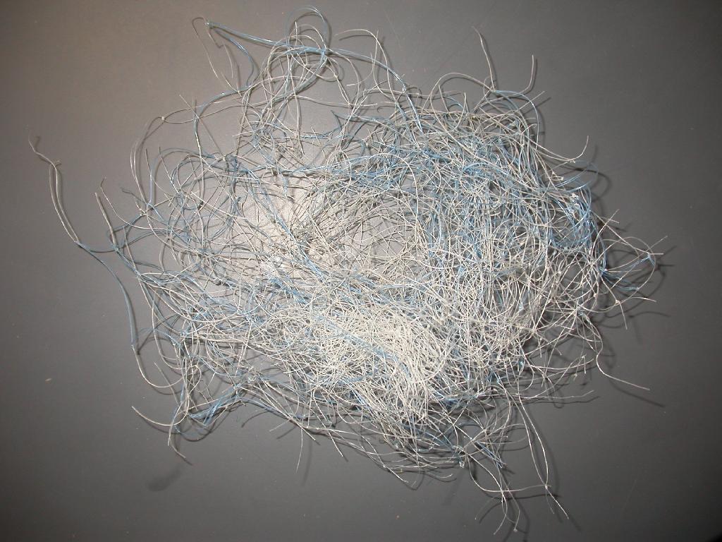 Sortirani kosi odpadnih ribiških mrež, nepravilnih oblik, z velikostjo odprtin 6 x 6 cm, ki so izdelani z vozlanjem sintetičnih, poliamidnih monofilamentov (premera manj kot 1 mm), bele in modre barve. Kosi so raztrgani, umazani in neuporabni za ponovno ribarjenje.

Uporabljajo se za recikliranje in ponovno predelavo v polimer poliamid 6.

Pakirani so v bale.