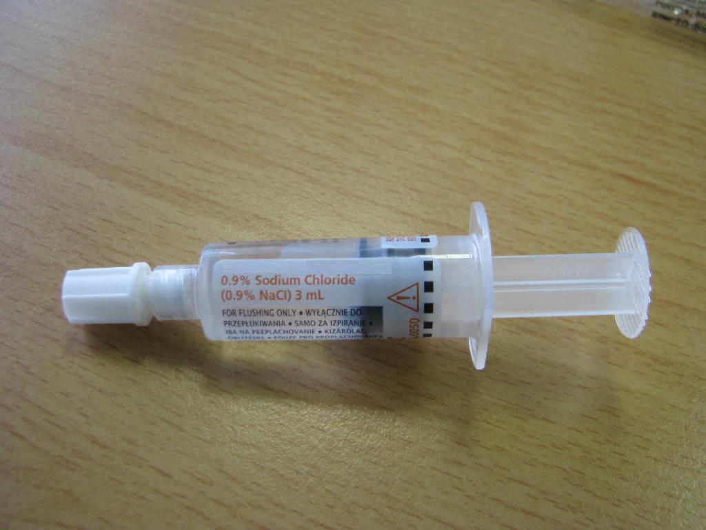 Plastična brizgalka volumna 3, 5 ali 10 ml, napolnjena z 0,9 % vodne raztopine natrijevega klorida (NaCl). Premer brizgalke je v vseh primerih enak, da se zagotovi ustrezen tlak pri uporabi. Brizgalka ima luer-jev navoj na izhodnem delu, ki omogoča priključitev na različne vrste intravenoznih  katetrov. Za zagotavljanje neoporečnosti fiziološke raztopine do uporabe je na izhodnem navoju plastični zamašek. Gumijasti bat je na začetku pritisnega dela izdelan iz debelejše gume, da preprečuje nastanek krvnega refluksa in izboljšajo uspešnost prebrizgavanja intravenoznega katetra. 

Bistveni del izdelka predstavlja raztopina natrijevega klorida.
 
Izdelek je namenjen za medicinsko uporabo, za prebrizgavanje ali spiranje intravenoznih katetrov, ki so vstavljeni v telo pacienta. Izdelek je namenjen za enkratno uporabo.