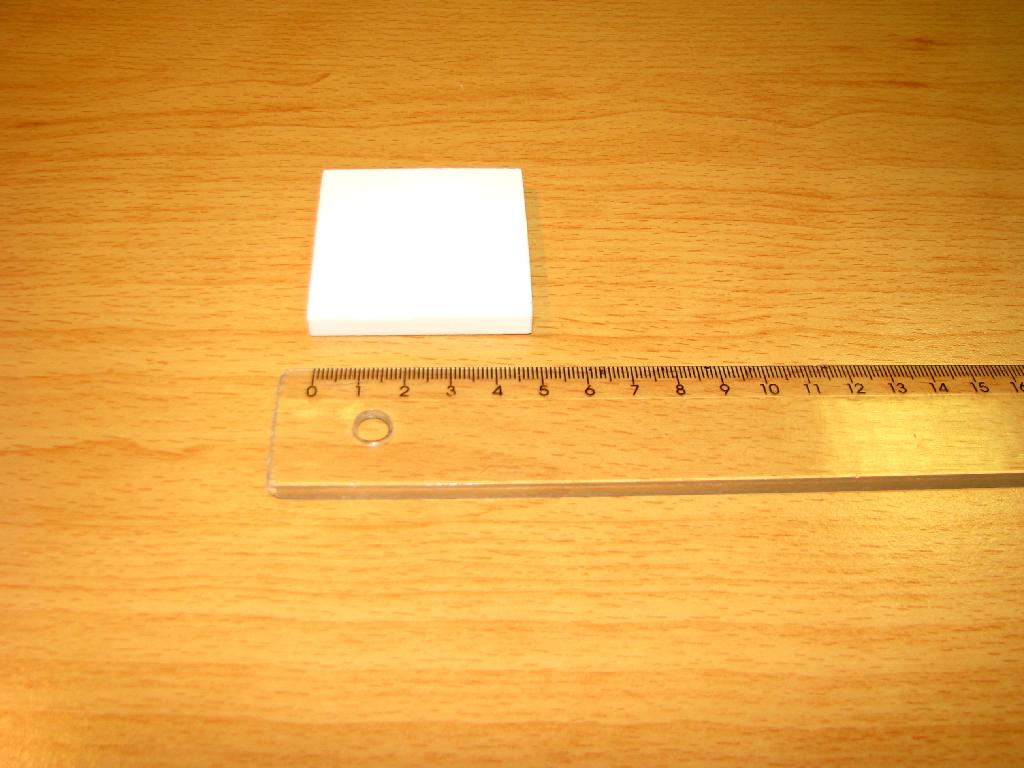 Keramična ploščica, kvadratne oblike, bele barve, oblikovana s prešanjem in nato žgana pri 1600 °C. Narejena je iz 92 % aluminijevega oksida. Lahko ima luknjo ali ne, dimenzije so 50 x 50 x 6 mm. Ploščica je odporna proti korozivnim vplivom in obrabi. Zdrži temperaturo 1500 °C. Uporablja se kot ognjevarni izdelek za oblaganje notranjosti peči, kjer je izpostavljena zelo visokim temperaturam.
