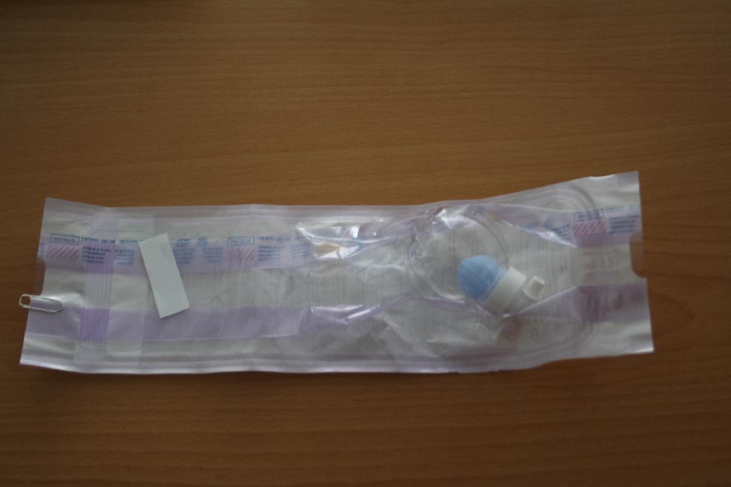 Pripomoček za uravnavanje in regulacijo tlaka (manostat), sestavljen iz delov iz plastike in raztezljivega kompenzacijskega balončka. Naprava je namenjena vzdrževanju zračnega tlaka 20 – 30 cmH2O (1961,28 – 2941,92 Pa) v mešičku tubusa, ki obdaja kanilo vstavljeno v sapnik (traheostoma) bolnika. Naprava ima na ohišju dva priključka, ki se lahko priključita na luerjev cevni nastavek. Pri montaži sistema se nastavi tlak, ki ga nato naprava vzdržuje s pomočjo napihljivega elastičnega barvnega balona v prozornem ohišju naprave, ki se širi ali stiska, glede na različen zunanji zračni tlak. 

Naprava je namenjena zmanjšanju morebitnih poškodb sapnika in rizika aspiracije pri bolnikih, pri katerih je bila izvedena traheotomija. 

Pakirana je sterilno v plastično embalažo in je namenjena za enkratno uporabo.