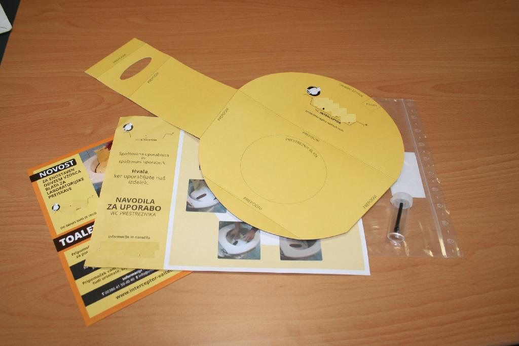 Komplet za odvzem vzorca blata za laboratorijske namene, ki ga sestavljajo:

- obojestransko plastificiran karton s krilci, potiskom in pregibi, katerega namen je, da ujame in zadrži blato (t.i. toaletni prestreznik),
- zbiralnik iz plastične mase, ki ga sestavljajo zbiralna epruveta (polistiren- PS) in pokrovček (polietilen- LDPE), na katerega je pritrjena žlička (polietilen- LDPE) za odvzem vzorca,
- obojestransko plastificiran trak iz kartona, ki se prilepi na prestreznik,
- navodila za uporabo,
- tiskan letak.

Komplet je pakiran v polietilensko vrečko z zip zapiranjem, dimenzij 250 x 350 mm. 

Bistvo izdelka predstavlja plastični zbiralnik, ki je namenjen zbiranju, hranjenju in transportu vzorca blata.