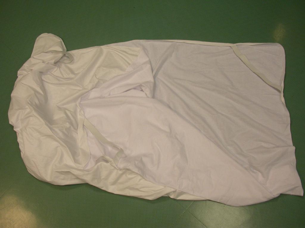 Zaščitna prevleka za vzmetnico, velikosti 160 x 200 cm, z zaobljenimi vogali, na katere so našiti elastični trakovi za pritrditev na vzmetnico. Rob prevleke je obšit. 
Pakirana je v plastično vrečko.
Prevleka se lahko enostavno odstrani z vzmetnice in je primerna za pranje. Iz tega izhaja, da ima objektivne značilnosti in lastnosti posteljnega perila.
Prevleka je izdelana iz pletenine (80% bombaž, 20% poliester) z zankasto površino, ki je na hrbtni (notranji) strani prevlečena s plastično, poliuretansko folijo, bele barve.