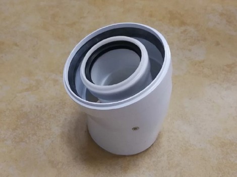 Dimniško koleno za nizkotemperaturne ter oljne kondenzacijske in plinske kondenzacijske kotle, s kotom od 15°do 90°, iz dveh togih kosov cevi, notranje in zunanje cevi.
Notranja cev leži v sredini zunanje cevi, na mestu jo drži en °pritrjevalnih nosilcev iz aluminija ali plastike (polipropilen). Funkcija notranje cevi je odvod zraka, ki je bil uporabljen za zgorevanje. Funkcija zunanje cevi je dovod svežega zraka po jašku med stenama zunanje in notranje cevi, ki se porabi za zgorevanje.
Notranje cev je narejena iz polipropilena, z metodo vlivanja, debeline od 1,8 mm do 2 mm, v premeru od 60 mm do 110 mm. Zunanja cev je narejena iz aluminija, z brezšivnim zvarom, debeline 0,4 mm do 0,6 mm, v premeru od 100 mm  do 150 mm, prašno barvana. Ena stran notranje in zunanje cevi je razširjena s silikonskim ali plastičnim (polipropilen) tesnilom, za namene nepredušnega povezovanja z drugimi elementi v dimovodnem sistemu.
Vsi elementi dimniškega kolena zdržijo konstantno delovno temperaturo do 120°C. Teža dimniškega kolena ne presega 0,50 kg.
Izdelek je mogoče šteti za del, saj ga je mogoče prepoznati, da je izključno namenjen ter nujno potreben za delovanje kotla za centralno kurjavo.