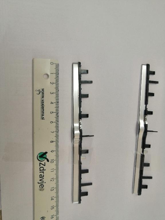 Plastični okvir pravokotne oblike dolžine 154 in širine 22 mm.
Uporablja se kot okvir za sprednje plošče za avtoradie/klimatske naprave na armaturni plošči v avtomobilu.
Narejen je iz akrilonitril-butadien-stirena (ABS) in polikarbonata, prekrit s plastjo bakra (debeline 15 µm), niklja (7 µm) in kroma (0,3 µm). Debelina prevleke je manjša od 49 µm.