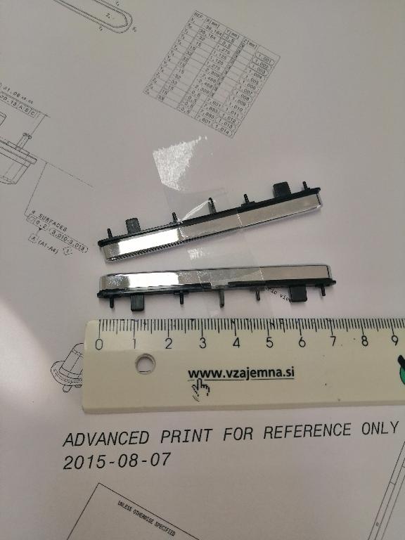 Plastični okvir pravokotne oblike dolžine 73 in širine 10 mm.
Uporablja se kot okvir za sprednje plošče za avtoradie/klimatske naprave ali kot okvir za gumbe za avtoradie/klimatske naprave na armaturni plošči v avtomobilu.
Narejen je iz akrilonitril-butadien-stirena (ABS) in polikarbonata, prekrit s plastjo bakra (debeline 15 µm), niklja (7 µm) in kroma (0,3 µm). Debelina prevleke je manjša od 49 µm.