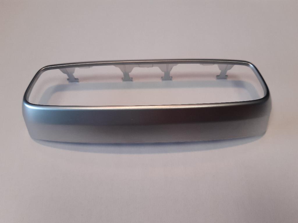 Okvir iz plastične mase pravokotne oblike z zaobljenimi robovi. Dolžina okvirja je 171 in širina 64 mm.
Uporablja se kot okvir za klimatske naprave v podaljšku ogrodja naslona za roke (odlagalni prostor).
Narejen je iz akrilonitril-butadien-stirena (ABS) in polikarbonata, galvansko prevlečen s sloji bakra (debeline 15 µm), niklja (7 µm) in kroma (0,3 µm).