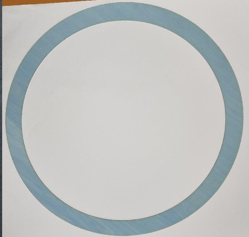 Izdelek v obliki kolobarja, izdelan iz mineralnih materialov, modre barve, z zunanjim premerom 650, notranjim premerom 560 in debelino 1 mm.
Uporablja se kot tesnilo cilindra za zalogovnik mešalnika v procesu izdelave gume, saj zelo dobro prenaša temperaturne obremenitve ( od -73 °C do +371 °C) kot tudi tlak (do 70 barov).
Tesnilo je narejeno iz gline (kaolina ≤ 75 %), nitrilne gume (≤ 15 %) in aramidnih vlaken (≤ 15 %). Izdelano je s postopkom stiskanja, kjer se kot vezivo uporablja nitrilna guma. Bistven značaj izdelku daje mineralno polnilo (kaolin).