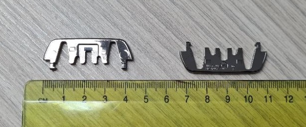 Dekorativni del podolgovate ploščate oblike iz plastične mase z največjo dolžino 43.3, višino 15.8 in debelino 2.8 mm, ki ima na eni strani po celotni dolžini več zob za pritrditev.
Uporablja se kot okvir klimatske naprave na sprednjem delu armaturne plošče v avtomobilu.
Izdelani so iz akrilonitril-butadien-stirena (ABS) in polikarbonata, galvansko prevlečeni s sloji bakra (debeline 15 µm), niklja (7 µm) in kroma (0,3 µm).