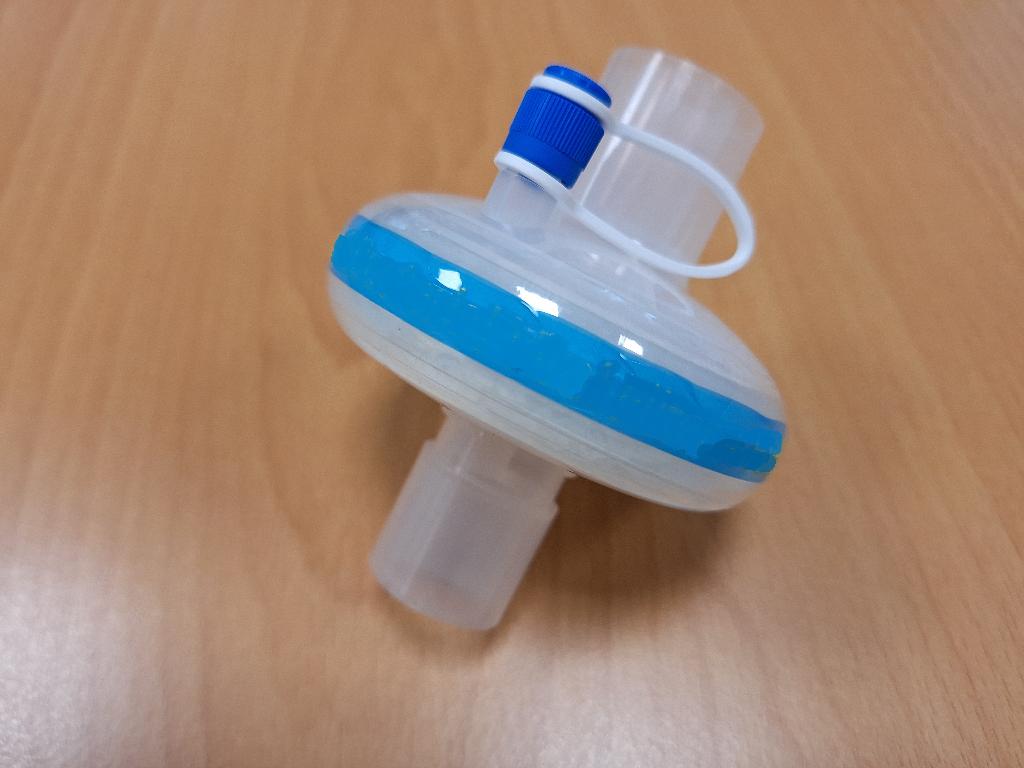 Filter za izmenjavo toplote in vlage (HMEF), sestavljen iz plastičnega ohišja, opremljenega z dvema 22-milimetrskima priključkoma (22F-22M) in enim luerjevim priključkom. Filter za izmenjavo toplote in vlage vsebuje tudi filtrirni material iz steklenih vlaken. Ima stisljivo prostornino 66 ml in tehta 41 gramov.
Izdelek ima naslednje funkcije:
— visoko učinkovito filtracijo (>99,999 %),
— olajševanje dihanja zaradi nizkega upora pretoka zraka (1,4 cm H2O),
— preprečevanje izgube toplote in vlage (vračilo vlage 33,6 mg H2O/L).
Izdelek je zasnovan tako, da se na enem koncu namesti na bolnikov priključek za dihalne poti (npr. obrazno masko), prek cevi pa se na drugem koncu poveže z aparatom za anestezijo ali umetno dihanje. Namenjen je za uporabo v intenzivni negi ali med anestezijo za preprečevanje vnosa virusov ter za ogrevanje in vlaženje zraka, ki ga vdihava bolnik.