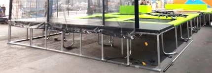 Komplet ogrodja v razstavljenem stanju za sestavo nosilnega ogrodja trampolina, izdelano iz zvarjenih cevi iz navadnih kovin, ki so razrezane na določene dolžine, krivljene, opremljene z luknjami za vzmeti in pripravljene za namestitev ponjave.
Nosilno ogrodje se uporablja kot del trampolina.