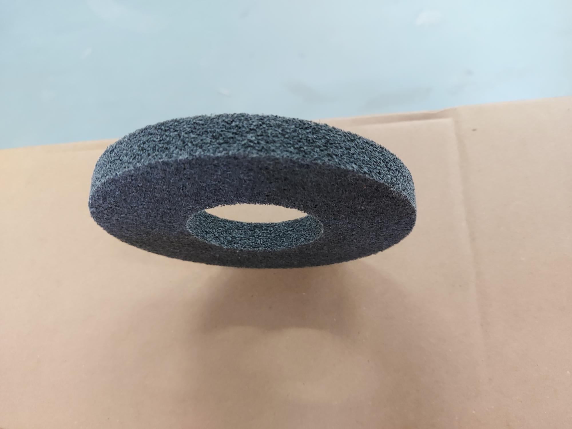 Izdelek je narejen iz netkanega tekstila v obliki okroglega obroča z zunanjim premerom 115  in debelino 12 mm. V sredini ima luknjo s premerom 50 mm. Na netkani tekstil so s smolo nanešena zrna silicijevega karbida, ki imajo funkcijo abrazivnega brusnega materiala. Velikost zrn je 0,022 mm.
Brusni obroči so namenjeni za izdelavo brusnih diskov za kotne brusilke.