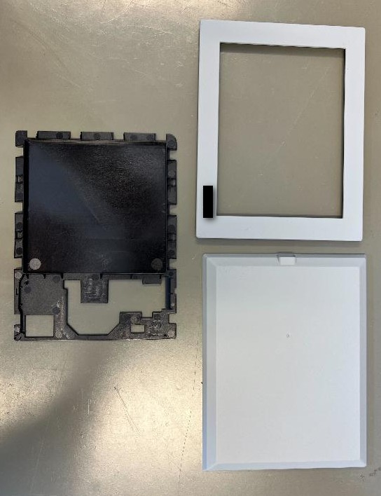 Plastično ohišje dimenzij 155 x 120 mm, namenjeno za izdelavo elektronske naprave, ki temelji na zaslonu s tehnologijo e-papirja. Ohišje je sestavljeno iz sprednjega dela z odprtino za ekran, zadnjega dela, ki se zapre skupaj s sprednjim in notranjega dela. Ohišje je lahko sive ali črne barve.
Uporablja se kot ohišje elektronske naprave iz tarifne številke 8528.