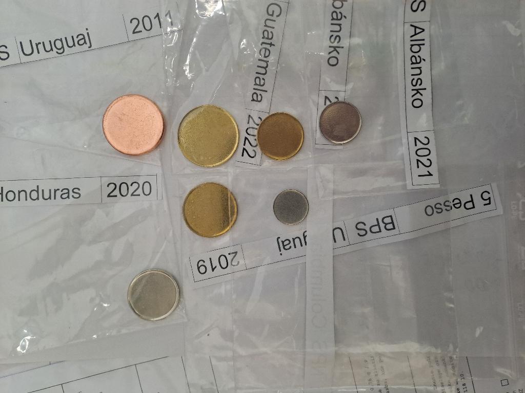 Ploché výrobky kruhového tvaru na výrobu minci  s hmotnosťou od 10,40 g - 2,00 g / tolerancia od +/- 0,284 - 0,06 g / s priemerom od 29,00 - 17,00 mm / tolerancia /+/-  od 0,08 mm do 0,10 mm /, hrúbka  od 2,50 - 1,30 mm / tolerancia +/- od 0,10 mm - 0,15 mm /. Výrobky sú vyrobené z ocele pokovené meďou / Cu /, niklom /Ni / a mosadzou / CuZN /. Jedná sa o nedokončené mince, ktoré idú ďalej do výroby na razbu, kde po narazení jednej aj druhej strany nezmení hmotnosť ani tvar. Tovar nie je zákonným platidlom.