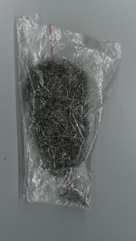 Oceľové drôtené vlákná, ktoré boli získané druhotným spracovaním použitých pneumatík narezaním na požadované dĺžky  a vytriedením gumy a oceľových kordov z pneumatík.  V súlade s poznámkou č. 8 a) k triede XV. ide o oceľový šrot položky 7204 z legovanej ocele.