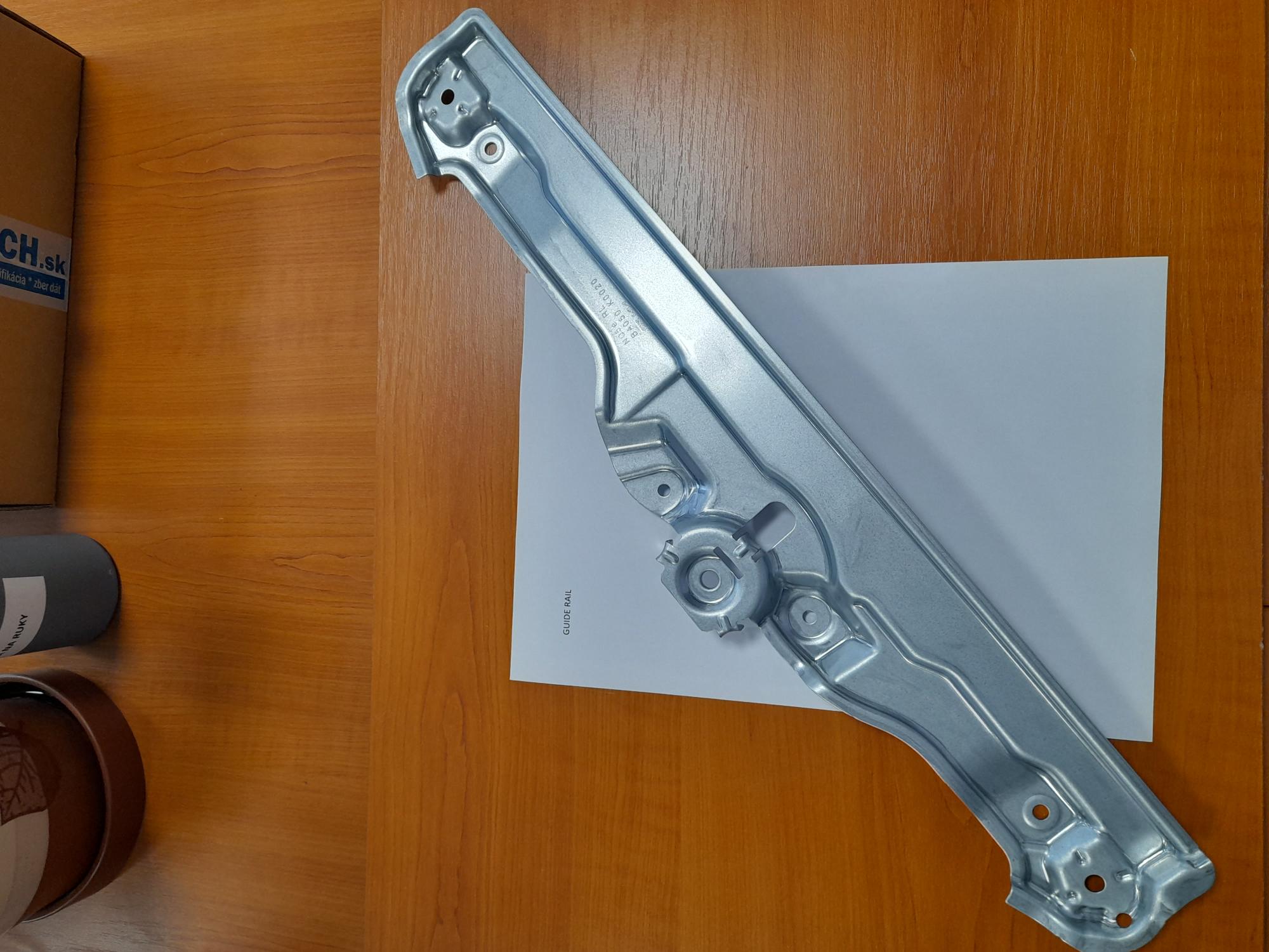 Tovarom je tvarovaný oceľový výlisok – koľajnička/lišta. Tovar sa používa ako časť mechanizmu na otváranie a zatváranie okien v motorových vozidlách. Po namontovaní všetkých dielov na tovar vznikne dverový regulátor/mechanizmus na otváranie a zatváranie okien, ktorý sa namontuje do dverí automobilu. Tovar je výlisok za studena lisovaný a vyrážané formou do presného tvaru z ocele, ktorá je pozinkovaná. Tovar obsahuje montážne otvory, pre uchytenie ďalších komponentov a pre upevnenie do dverí automobilu.