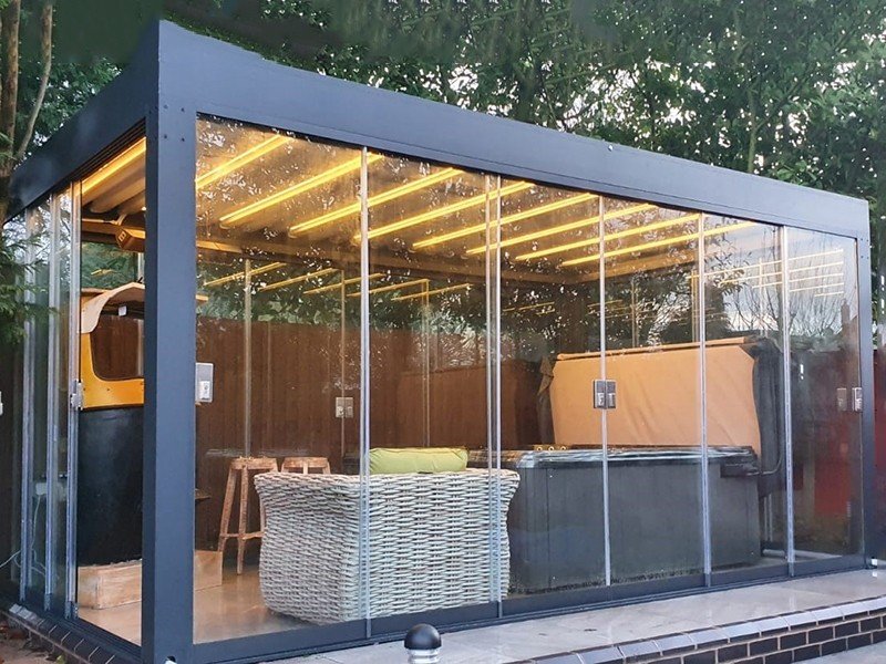 Permanent building structure to be used as a conservatory with aluminium frame and roof. The roof system consists of louvered blades which are motorised and can be opened and closed. The sides of the building are made from 10mm thickness tempered glass and incorporate sliding door panels. There is an in-built guttering system to the building with the water draining out from the corner struts. There is integral lighting as part of the roof system. The building can be attached to the residential house with three glass sides and the dimension of this product is 4M X 3M.
Permanent building structure to be used as a conservatory.
With aluminium frame and roof. The roof system consists of louvered blades which are motorised and can be opened and closed.
The sides of the building are made from 10mm thickness tempered glass and incorporate sliding door panels.
There is an in-built guttering system to the building with the water draining out from the corner struts. There is also integral lighting as part of the roof system.