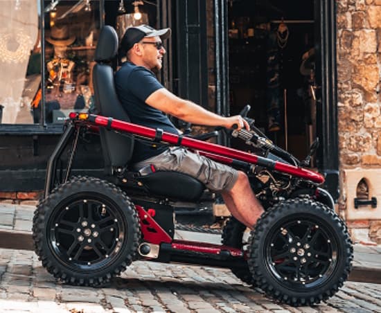 This is a 2-wheel drive off-road mobility vehicle with an all-round independent suspension system. It also has a side roll bar that lifts for easy access and to offer protection, as well as adjustable seating, backrest, and steering.
This mobility vehicle, has the ability to handle mud, grass, and inclines comfortably provides a sense of unparalleled freedom and exhilaration for the disabled person.
Dimensions: W = 850mm (can be reduced to 810mm); L = 1650mm; H = 1150mm (seat folded); H = 1410mm (seat unfolded)
Weight: 134.5KG (including battery)
Ground clearance: 120-180mm
Max. user weight: 102KG
Max side tilt: 20 degrees/36%
Max gradient: 17 degrees/30%
Max descent: 30 degrees/57% 
Max speed 8MPH UK: 8mph (outside of UK, dependent of country’s other countries permitted speed of mobility scooters)
Battery range: 50AH = 8-12 miles; 100AH = 16-24 miles; 200AH = 32-48 miles (Range is variable, dependent on speed, weight of user, type of terrain and ambient temperature).